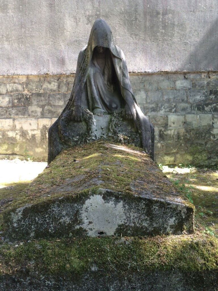 grave with crouched hooded statue